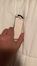 After the screws are removed, lift the hard-plastic cover to reveal the inside of the remote and locate the ZL button.