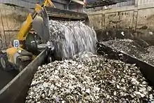 Bucket loader dumping a load of waste at a waste depot