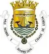 Couronne à cinq tours, écu avec la mer et un bateau surmonté de deux corbeaux, bannière avec devise.