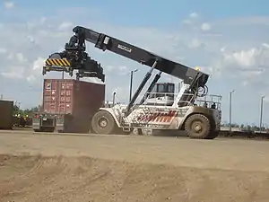 Peti kemas yang sedang dimuat dengan Reachstacker ke atas truk