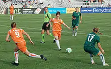 Jugadoras de fútbol femenino trabajando en equipo.